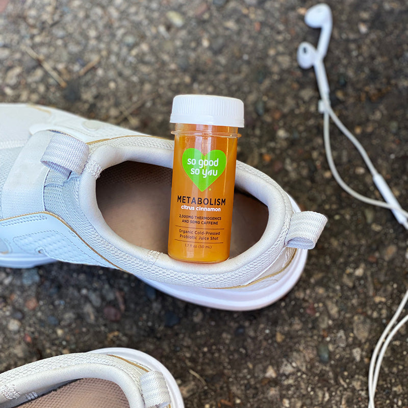 
                      
                        Metabolism Probiotic Juice Shot inside running shoes next to headphones
                      
                    