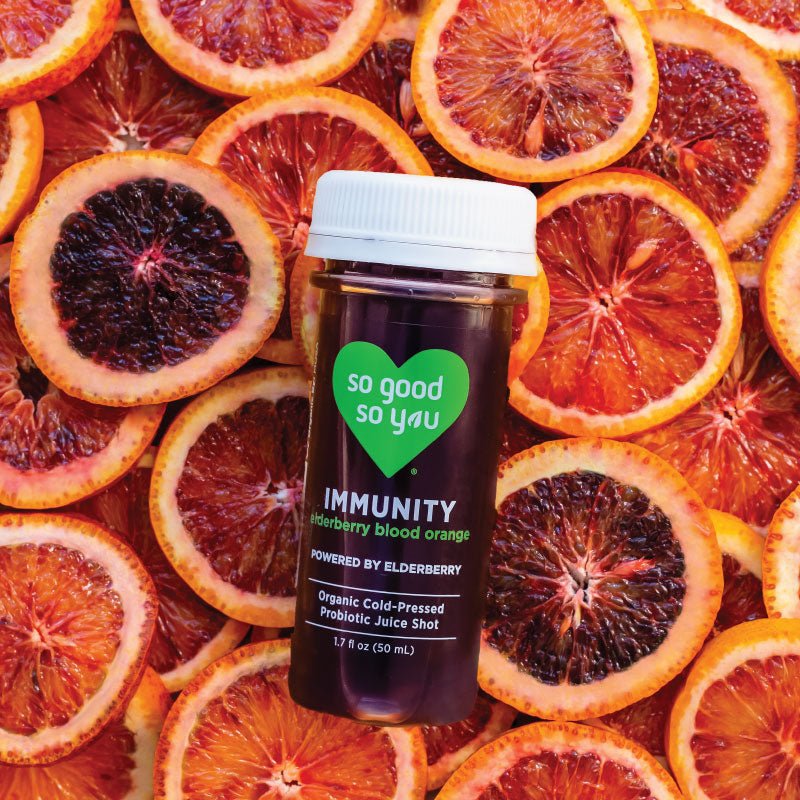 Immunity Elderberry Probiotic Juice Shot on top of raw blood oranges